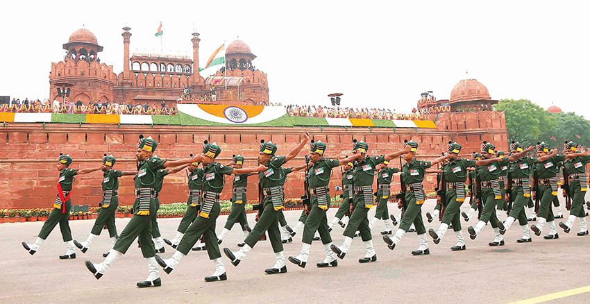 Indian flag hoisting at Red Fort Delhi on Independence Day with aerial drone view of crowds.