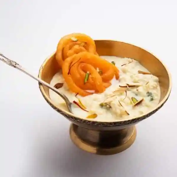 Golden crispy jalebi with thick rabri - sweet dessert at Old Delhi’s Chandni Chowk market.