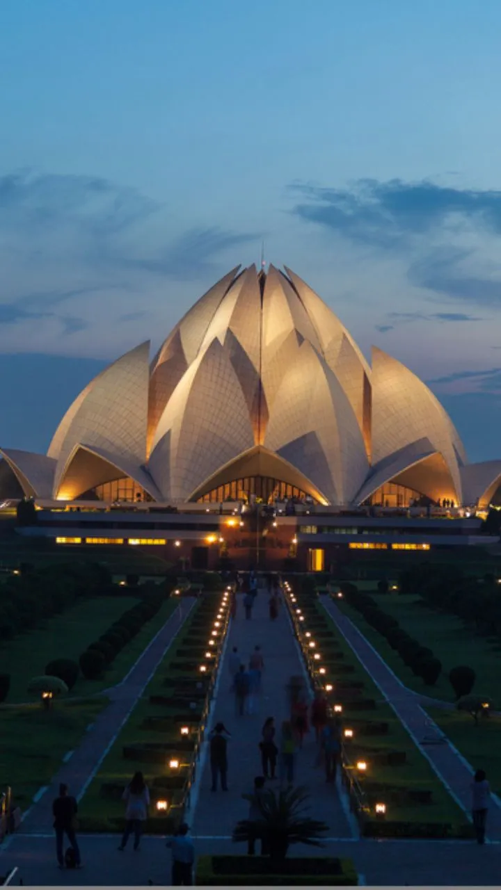 Stunning Baháʼí House of Worship shaped like a blooming lotus, surrounded by ponds.