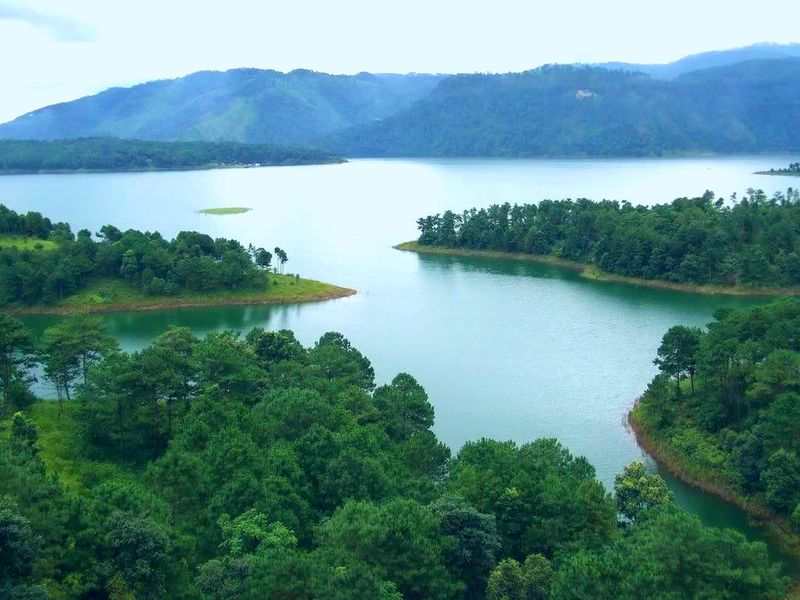 Sunset over Umiam Lake, Meghalaya - calm waters reflecting pine-covered hills.