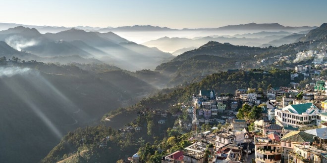 Aizawl cityscape at dawn with golden sunlight over terraced houses