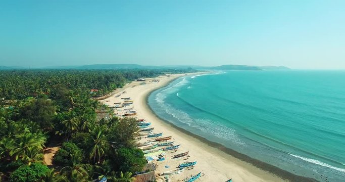 Mandrem Beach in North Goa - A peaceful stretch of white sand with swaying palms, clear turquoise waters, and rustic beach huts, perfect for relaxation.