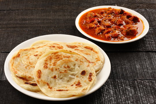 Flaky Malabar parotta with spicy beef fry, a popular street food in Kochi.