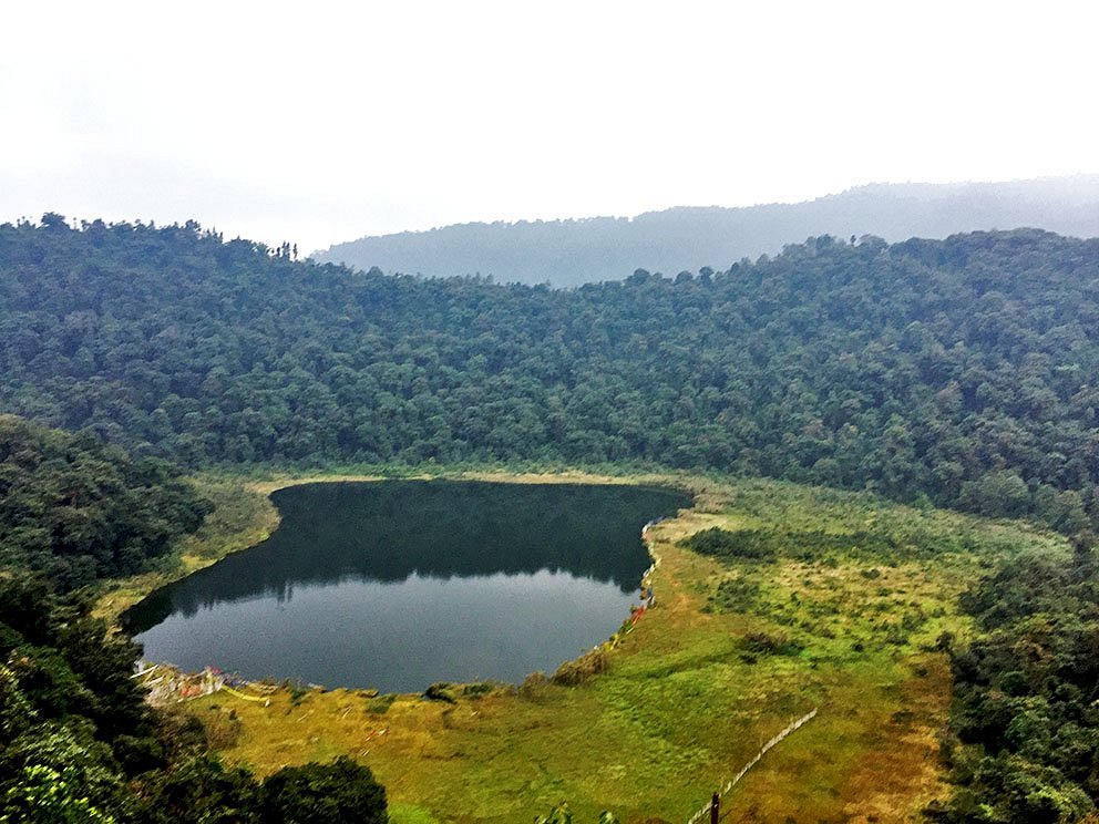 Khecheopalri Lake, a tranquil holy lake and mystical place to visit in Sikkim, nestled in dense forests.