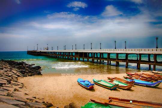 Sunset view at Promenade Beach in Puducherry with Gandhi Statue and ocean waves.
