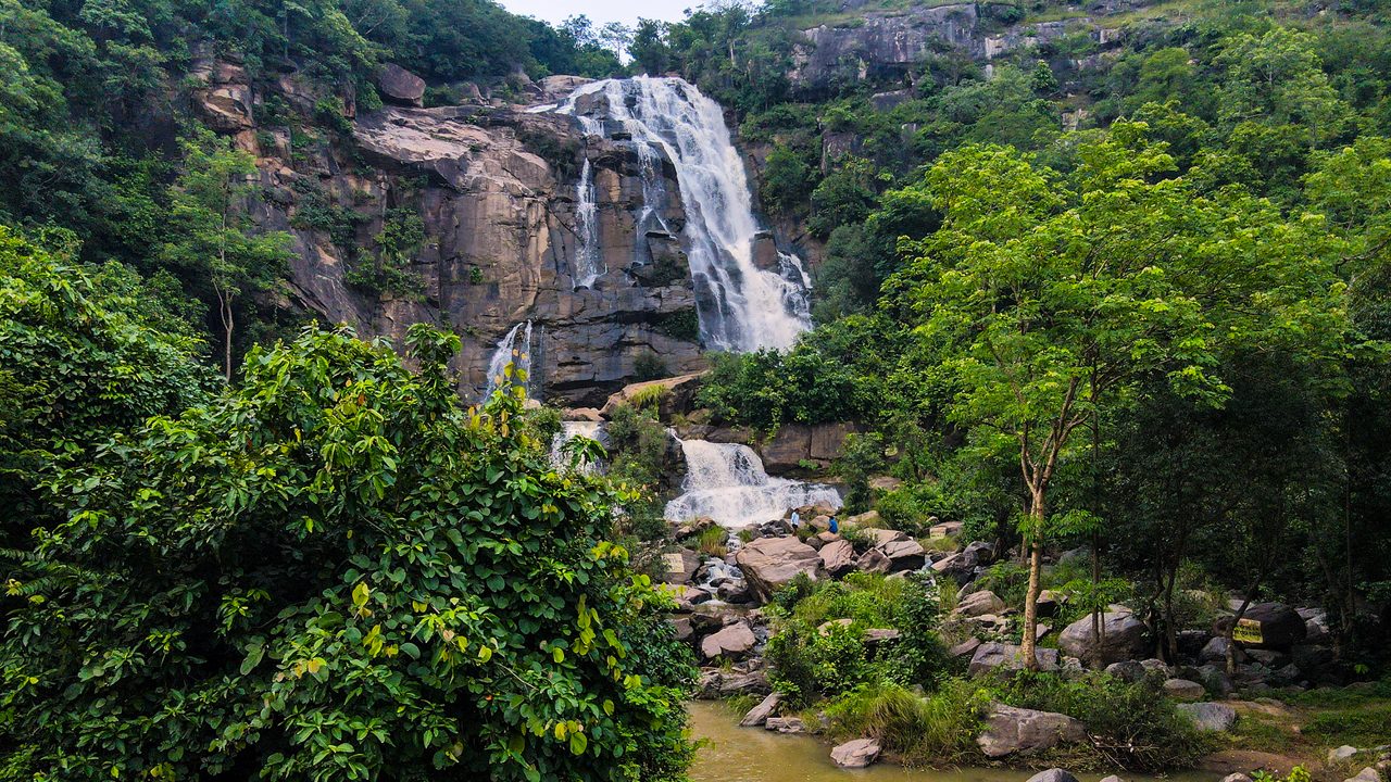 Sita Falls in Jharkhand flows gracefully through rocks and trees.