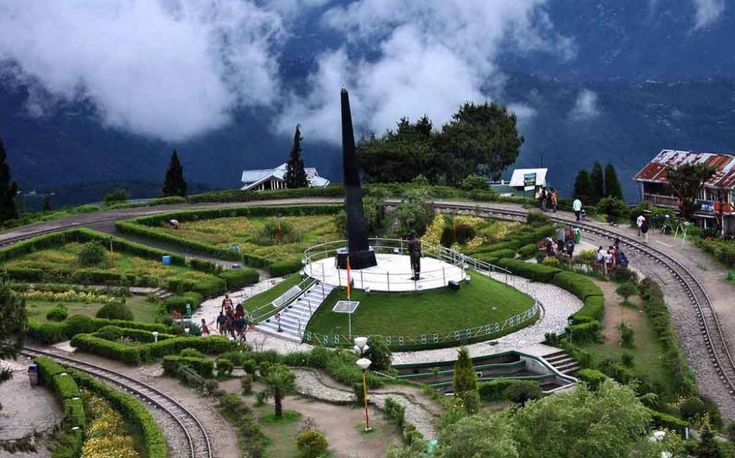 A spiral railway track with a beautiful garden and war memorial.