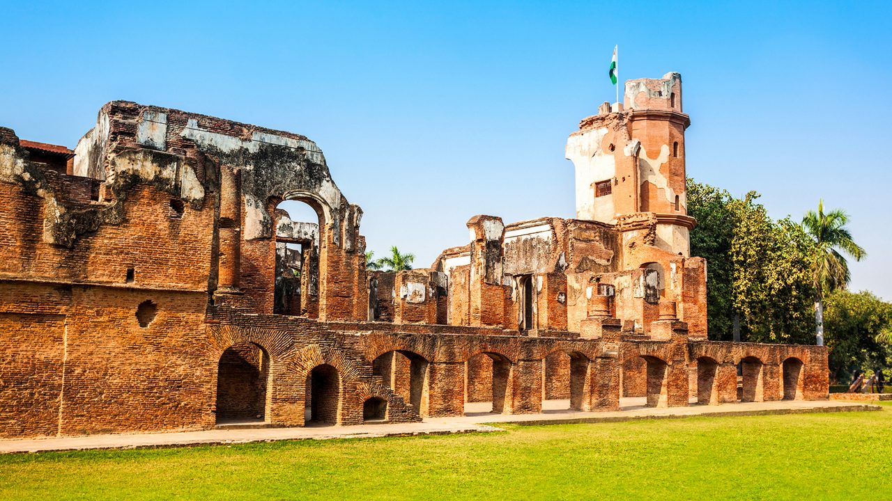 Ruins of British Residency surrounded by lush greenery.