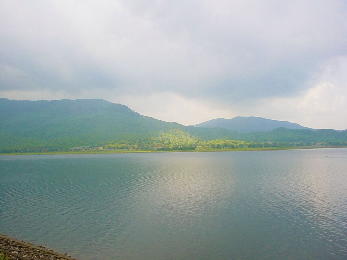 A tranquil lake surrounded by forests and hills.
