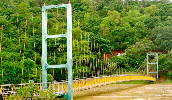 A picturesque lake with hanging bridges and boating options.