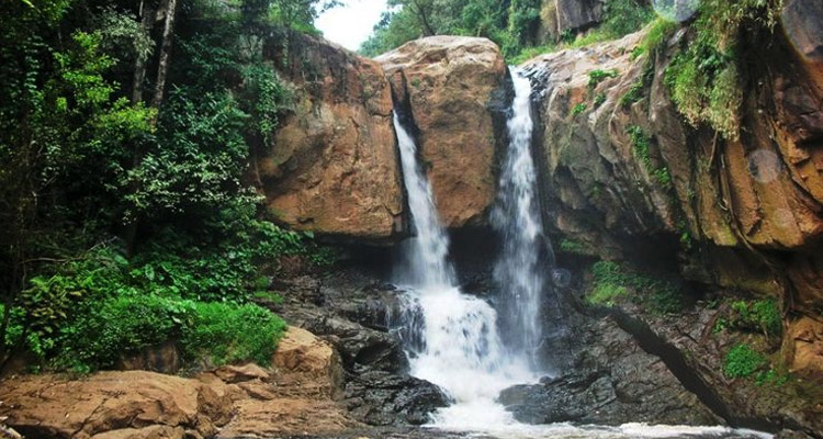 A beautiful cascading waterfall surrounded by dense forests, best seen in monsoon.