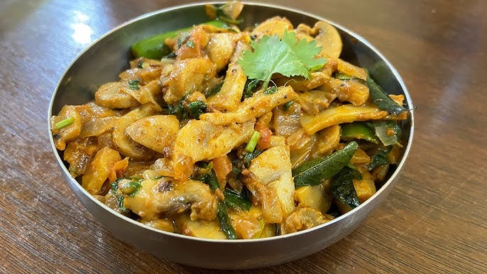 Traditional Ooty mushroom masala curry with fresh Nilgiri mushrooms, onions, and spices in clay pot