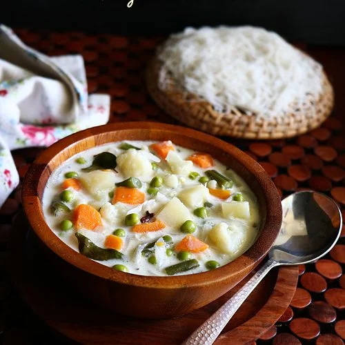 Assorted Ooty traditional dishes including stew, biryani, and mushroom curry on wooden platter