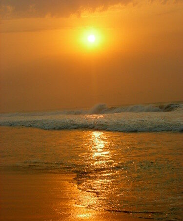 Golden sunrise over surfers at Rushikonda Beach, a top pick on our city page Visakhapatnam coastal escapes.