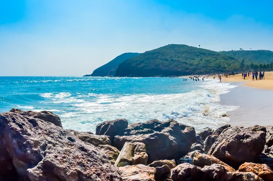 Places to visit in Visakhapatnam: Secluded Yarada Beach surrounded by green hills and clear waters.
