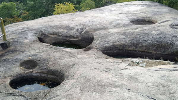 A sacred pond and Shiva temple surrounded by tranquil landscapes.