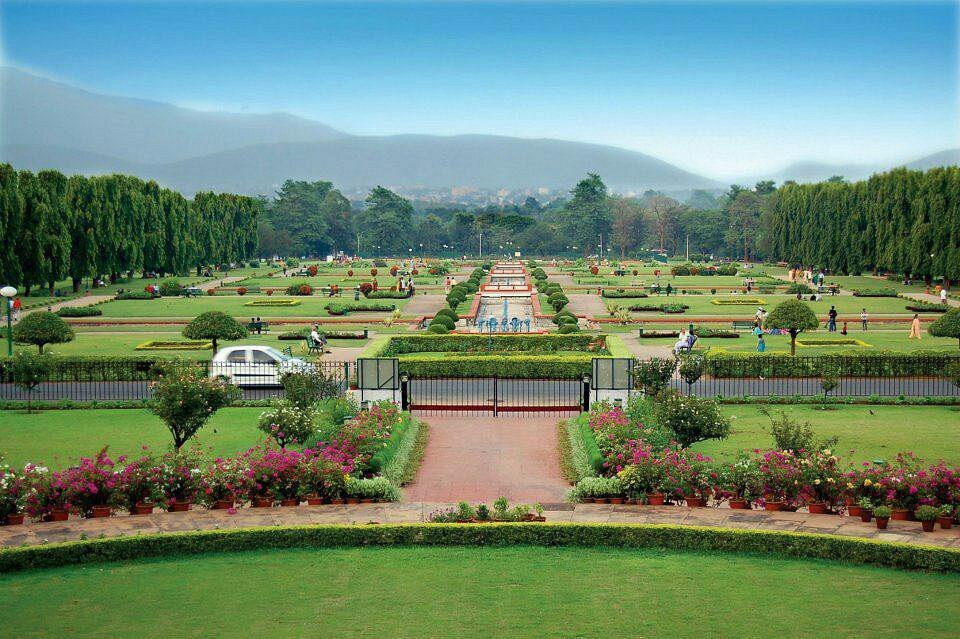 A wide-angle view of the expansive green lawns and fountain at Jubilee Park in Jamshedpur.