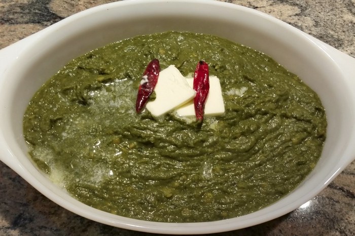 A bowl of Kandalee Ka Saag served with hot rotis
