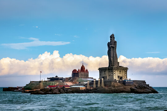 Sunrise over Kanyakumari’s rocky coastline, where the Arabian Sea, Bay of Bengal, and Indian Ocean meet, with the Vivekananda Rock Memorial and Thiruvalluvar Statue in the distance.