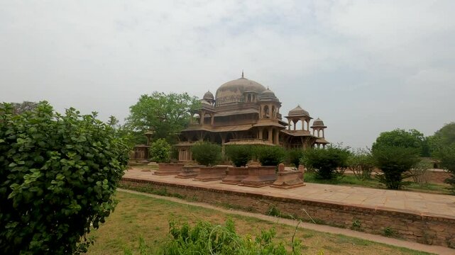 The serene and green surroundings of the Tomb of Tansen, a peaceful place to visit in Gwalior.
