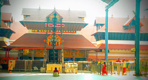 The serene and golden flagstaff (dhwajastambham) within the sanctum of Guruvayur Temple, a famous Krishna shrine in Kerala.