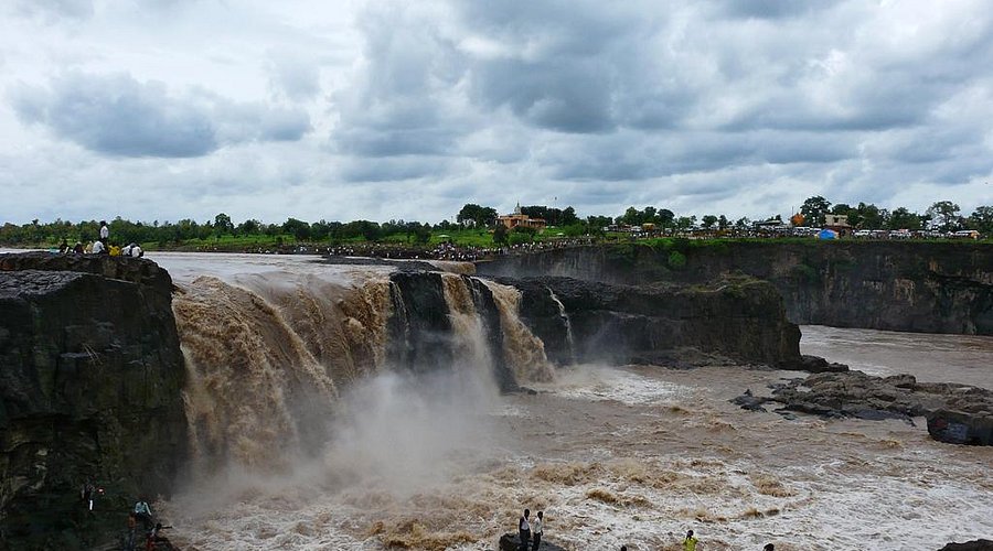 A series of seven natural rock pools formed by a cascading waterfall in a forested area.