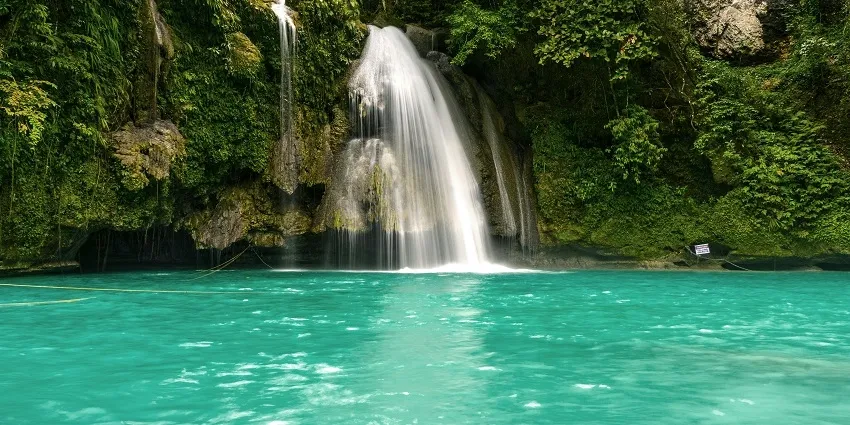 The towering, three-tiered giant of West India's Famous Waterfalls, cascading down a massive rock face in a secluded valley.