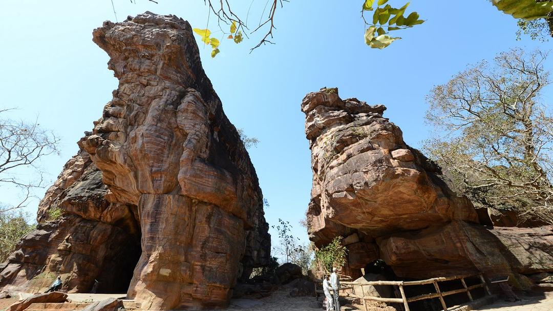 Prehistoric cave paintings depicting ancient animals and human figures inside the Bhimbetka rock shelters, a key site among Central India's Famous Archaeological Marvels.