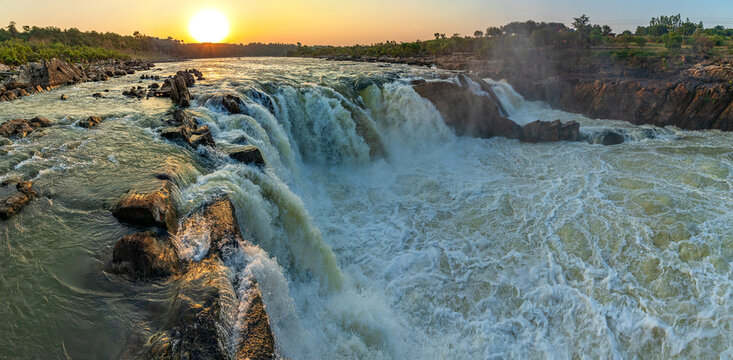 The Narmada River forcefully plunging into a marble canyon, creating a smoky mist that defines this iconic site among Central India's Famous Waterfalls.