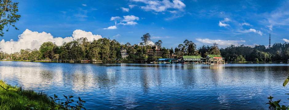 A peaceful boating scene on the sparkling waters of Kodaikanal Lake.