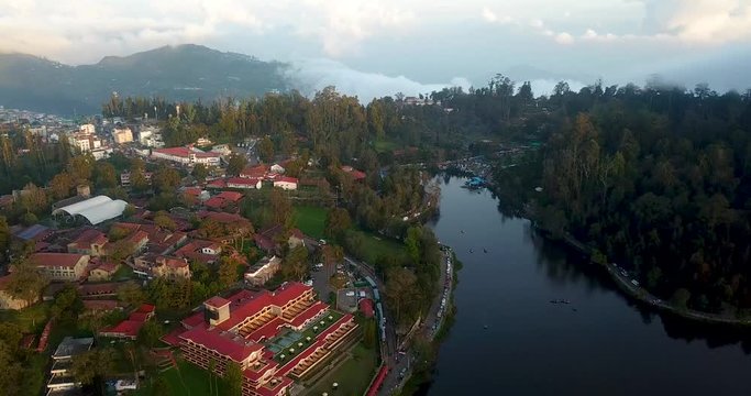 Panoramic view of Kodaikanal Lake surrounded by lush green hills with boating facilities visible.