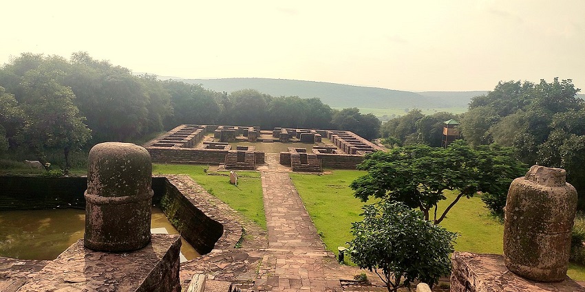 Ruins of the ancient monastic complex surrounding the stupas.