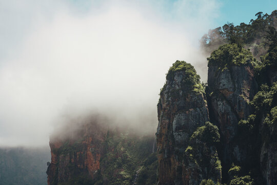 The three massive granite rock pillars standing tall against a backdrop of misty forests, a dramatic natural place to visit in Kodaikanal.
