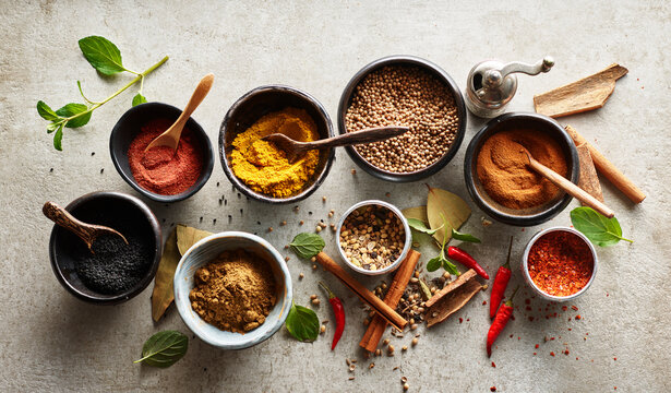 An assortment of vibrant and aromatic whole spices on a traditional plate.
