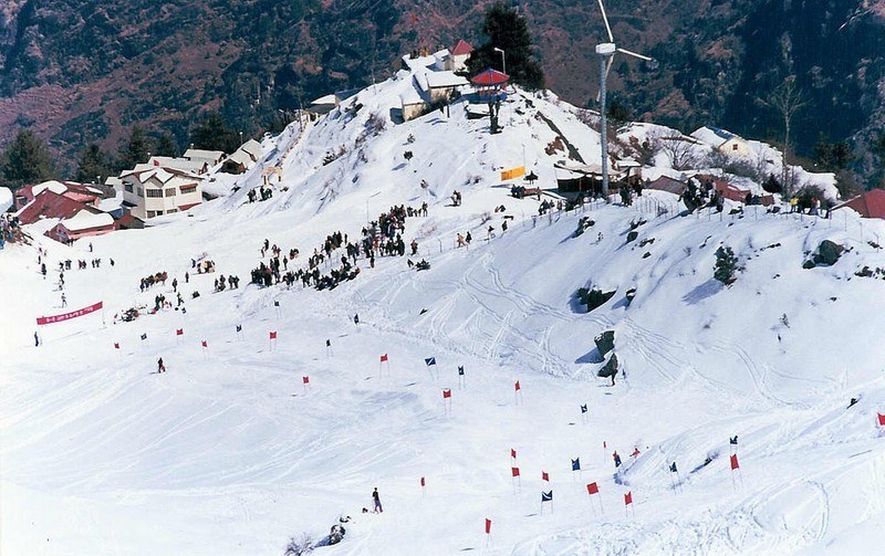 Skiers gliding down the pristine white slopes of the popular Auli Ski Resort during winter.