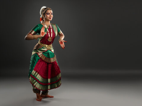 A dancer in a vibrant costume performing a Bharatanatyam pose.