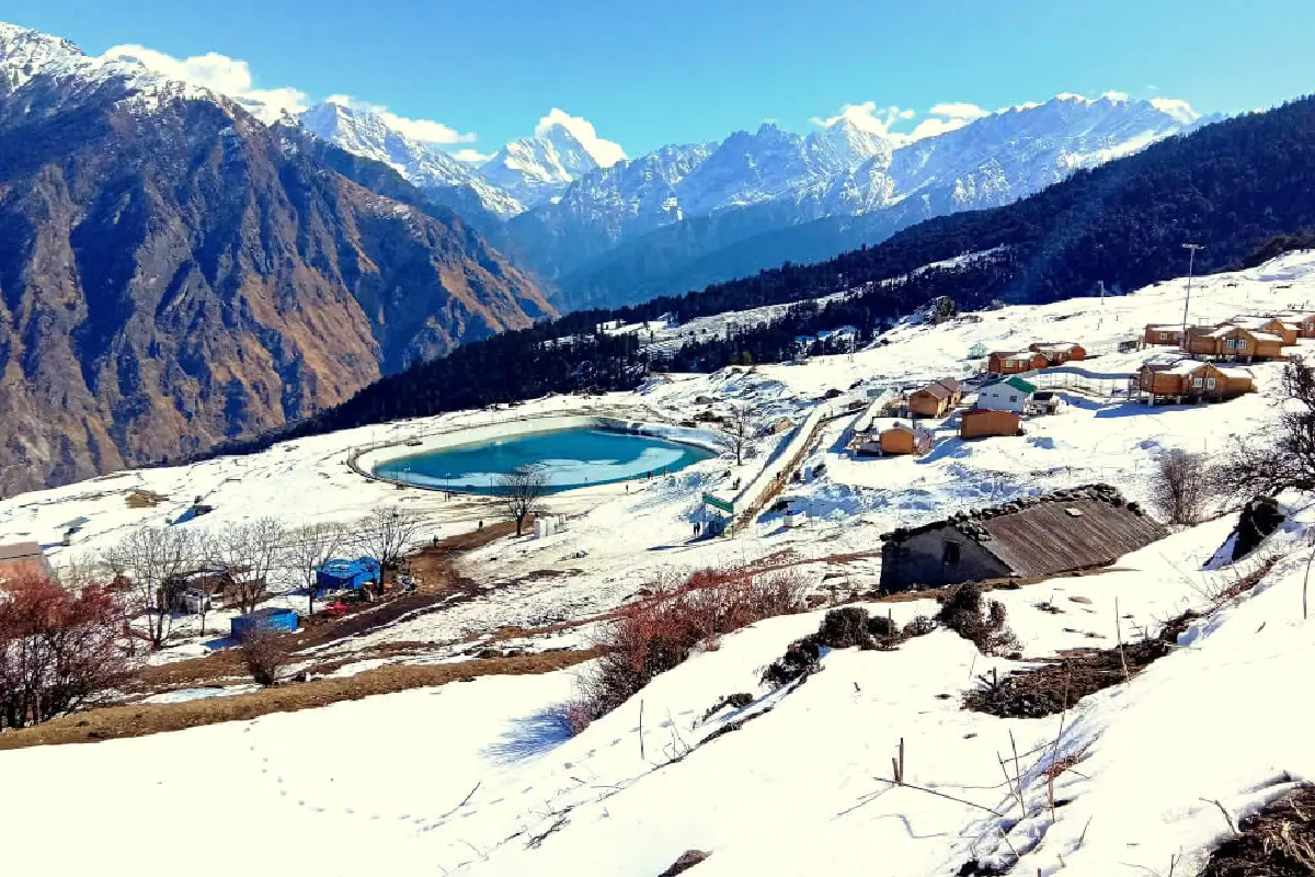 A wide, stunning landscape photograph of the peaks and valleys of the Garhwal Himalayas.
