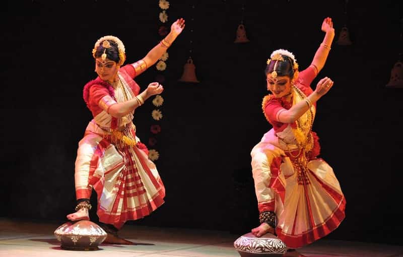 A classical Gaudiya Nritya dancer depicting a devotional Radha-Krishna pose with graceful hand movements.
