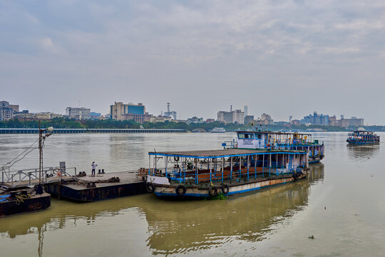 A public ferry boat on the Hooghly River with the Howrah Bridge visible in the background.