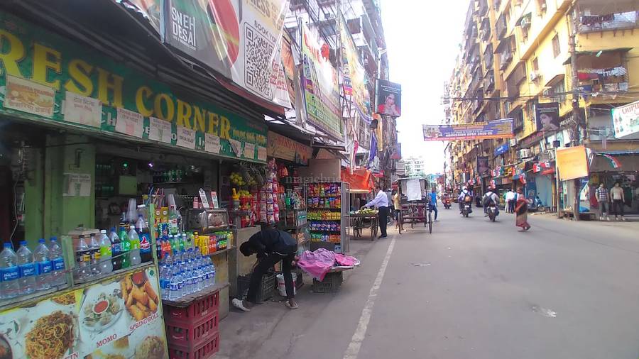 A crowded, vibrant lane inside the famous Howrah Market, filled with shops and electronics.