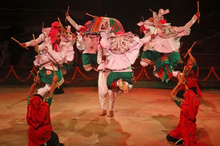 Women balancing lit earthen lamps on their heads during the Jhijhiya dance.