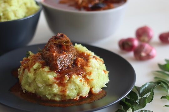A steaming bowl of tapioca (Kappa) paired with spicy fish curry (Meen Curry).