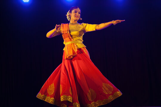 Kathak dancer in a traditional lehenga-choli performing intricate spins and expressive gestures.