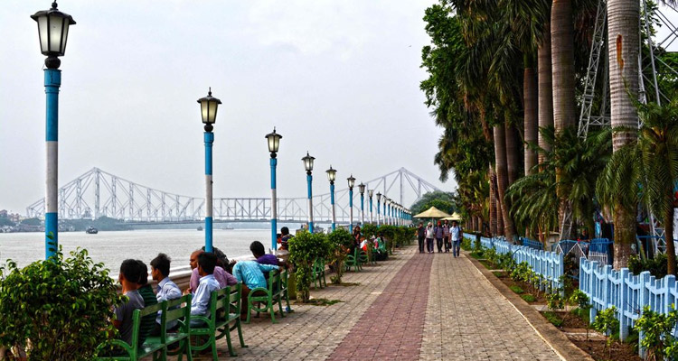 Families and visitors relaxing on the green lawns of Kolkata's Millennium Park riverside promenade.