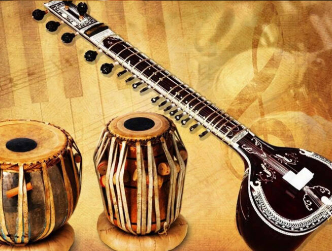 A musician performing Rabindra Sangeet on stage with a harmonium.