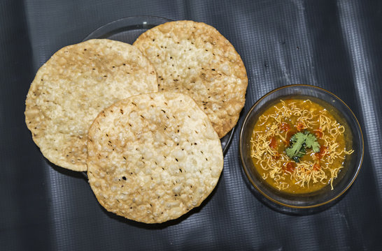 Bajra na Rotla (millet bread) served with Mahu (curry) on a brass plate.