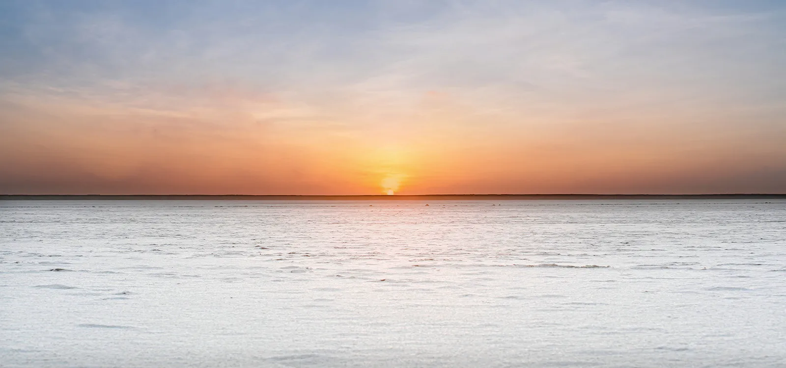 A beautiful sunrise reflecting in the ancient reservoirs of Dholavira.
