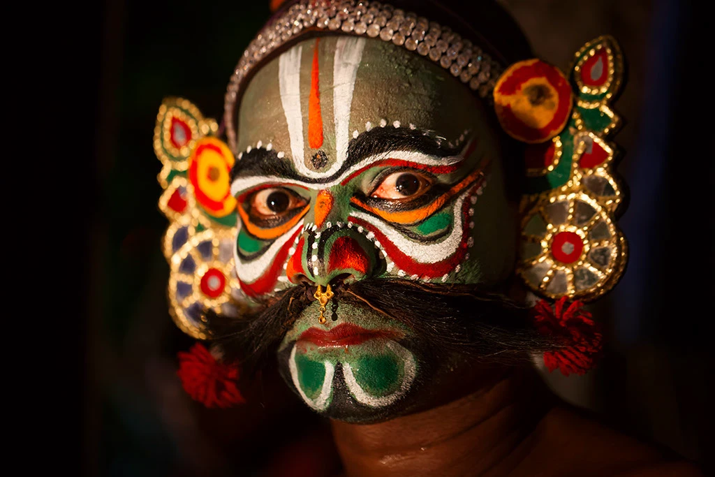 A vibrant street theatre performance of Therukoothu with colorful costumes and makeup.