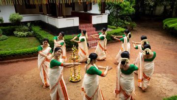 A circle of women in traditional Kerala attire performing the Thiruvathirakali dance.