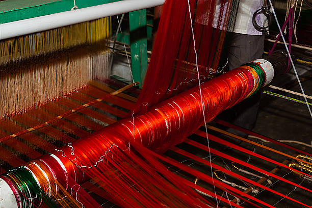 Artisans hand-weaving a vibrant Kanchipuram silk saree on a traditional loom.